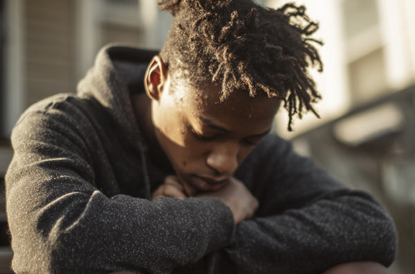 Young man sitting with his head lowered